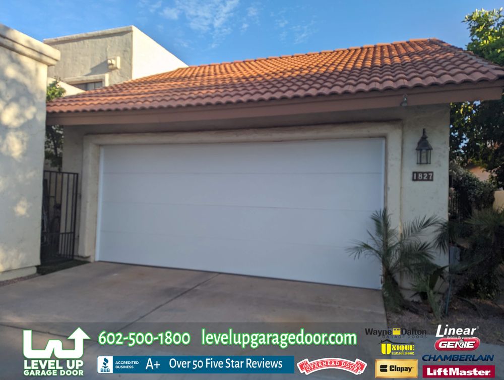 Two-car white garage doors installed on a tile-roof home in the East Valley, AZ