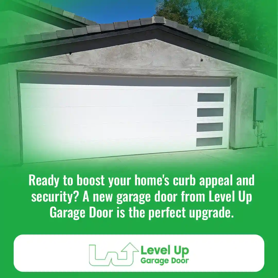 A modern, white garage door with a row of four rectangular, frosted windows on the right side, installed on a stucco house.